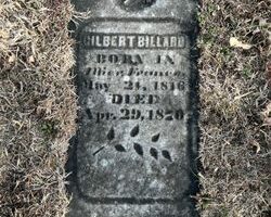 Weathered grave marker partially buried in grass, reading 'Gilbert Billard' with birth and death dates from the 1800s.