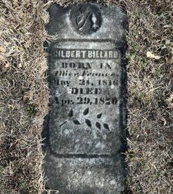 Weathered grave marker partially buried in grass, reading 'Gilbert Billard' with birth and death dates from the 1800s.